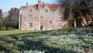 Exterior view of Chawton House with lawn and snowdrops