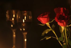 Roses and wine glasses in candlelight