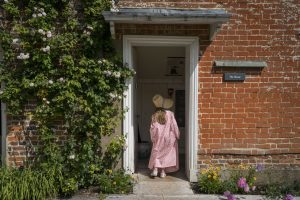 Little girl going into Jane Austen's House in period dress.